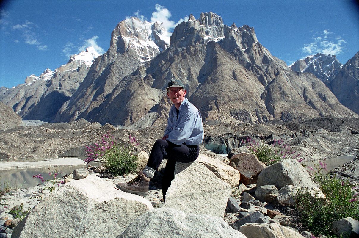 18 Jerome Ryan Poses Above Lake On Baltoro Glacier With Great Trango Tower And Trango Castle Behind Jerome Ryan climbed above a large lake on the Baltoro Glacier amid some grass and small flowers with Trango II, Great Trango Tower and Trango Castle behind � simply spectacular.